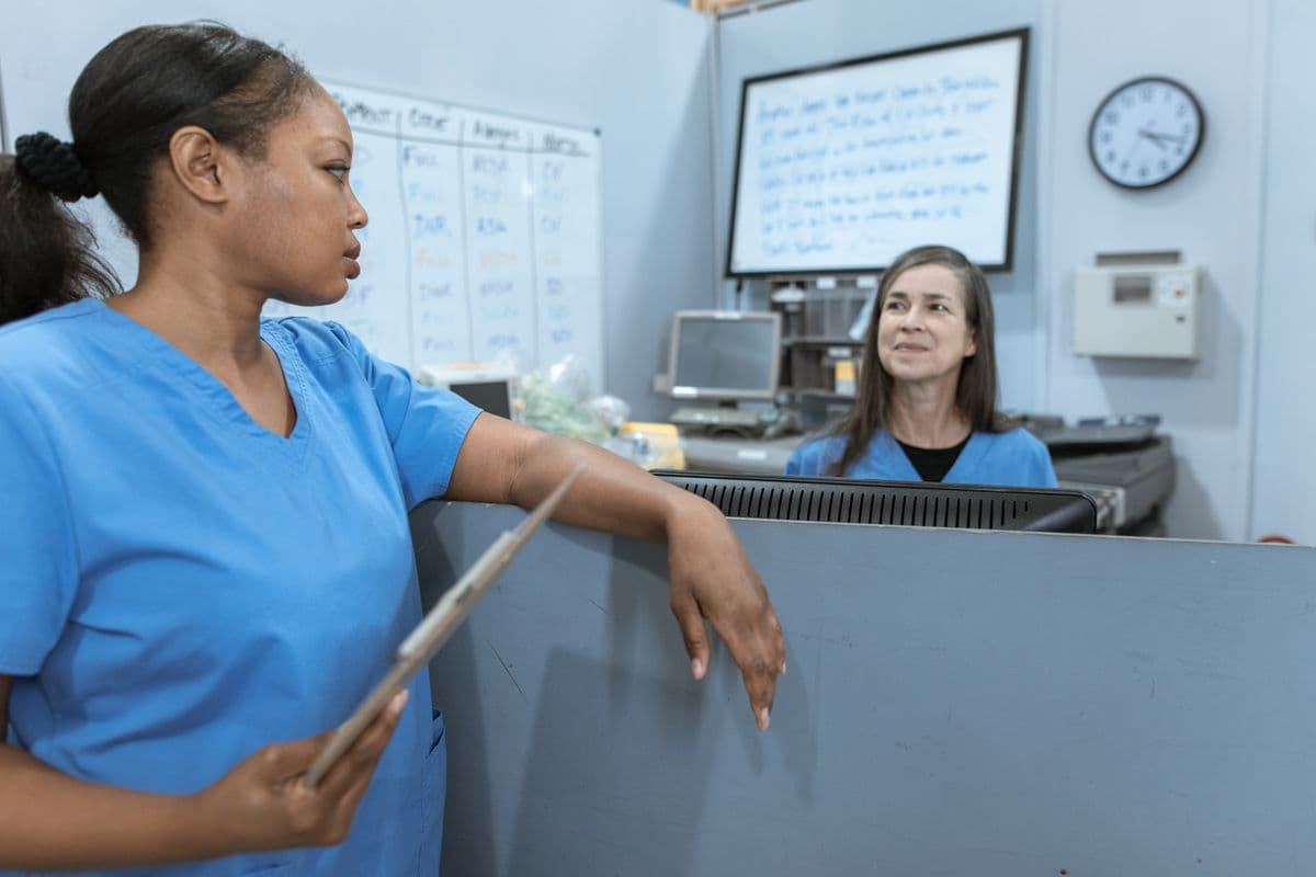 Nurses reviewing a clipboard together in a clinic