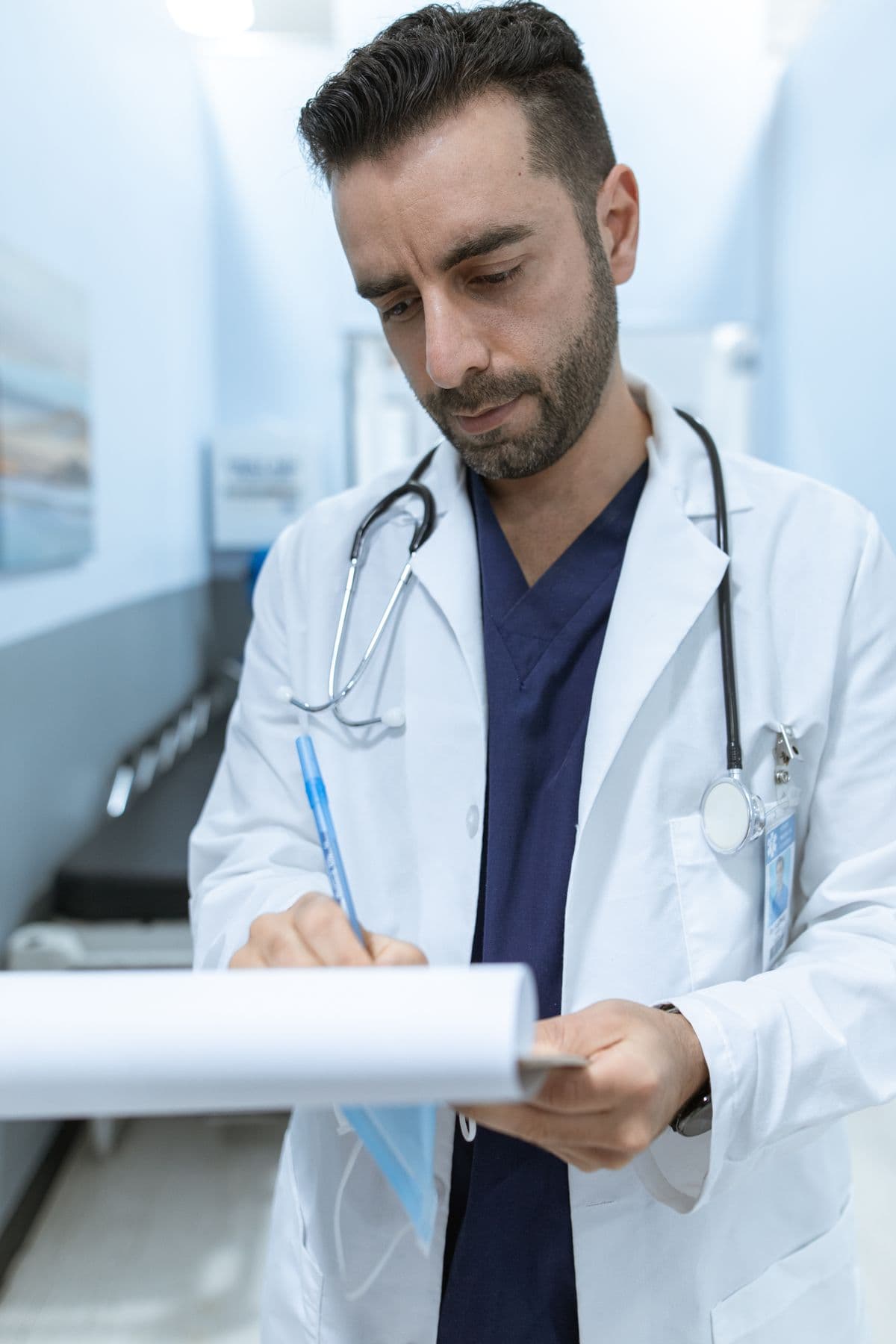 Doctor completing paperwork in a hospital hallway