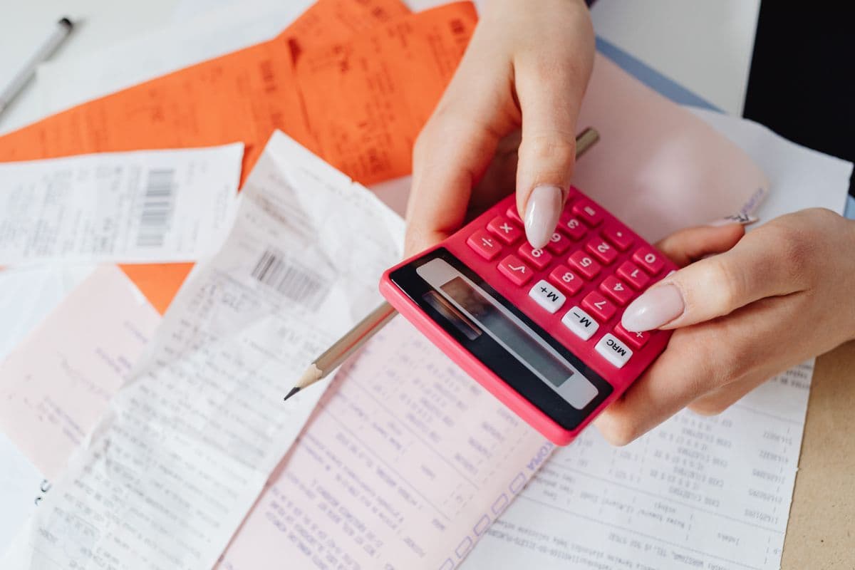 Hands using a calculator over financial documents
