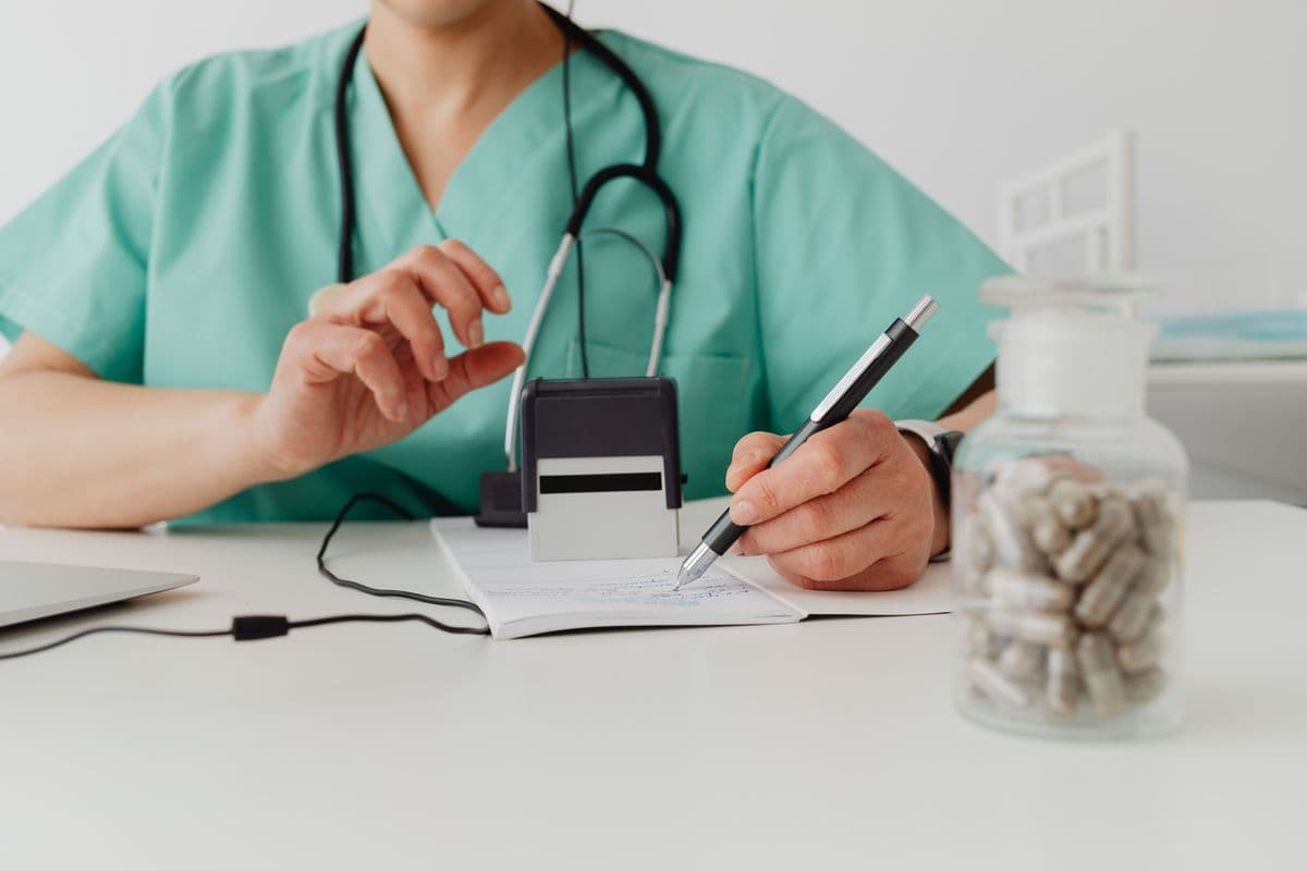 Medical professional writing notes in a clinical setting