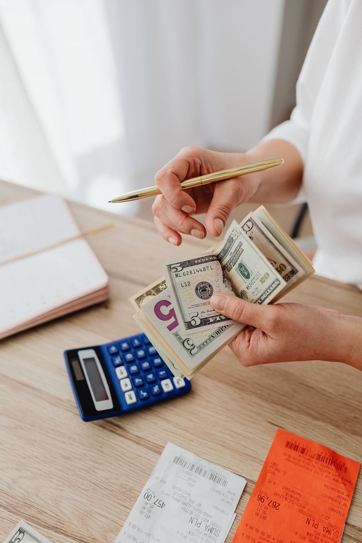 Person reviewing receipts with a calculator at a desk