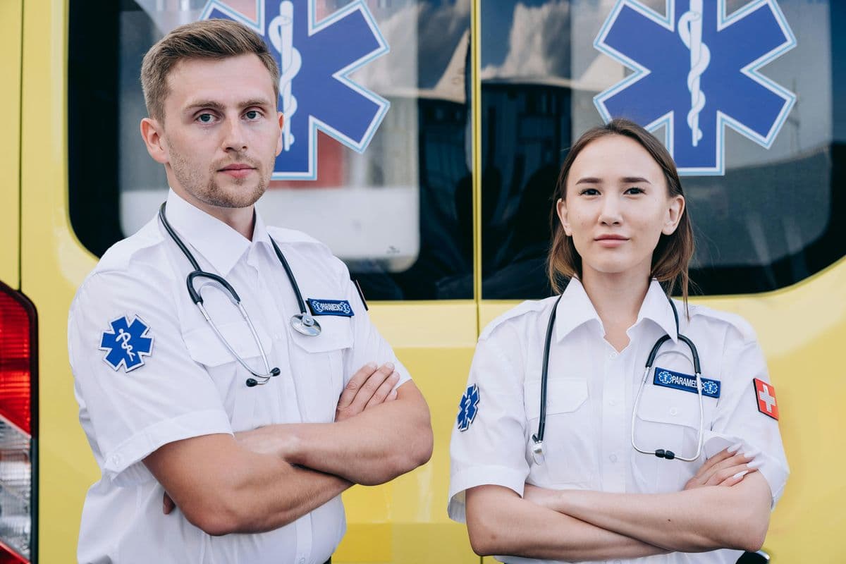 Two paramedics standing in front of an ambulance